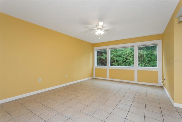 spare room with ceiling fan and light tile patterned floors