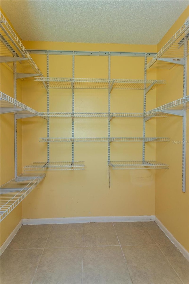 walk in closet with tile patterned floors