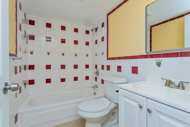 full bathroom featuring toilet, tiled shower / bath, tile walls, vanity, and tile patterned flooring