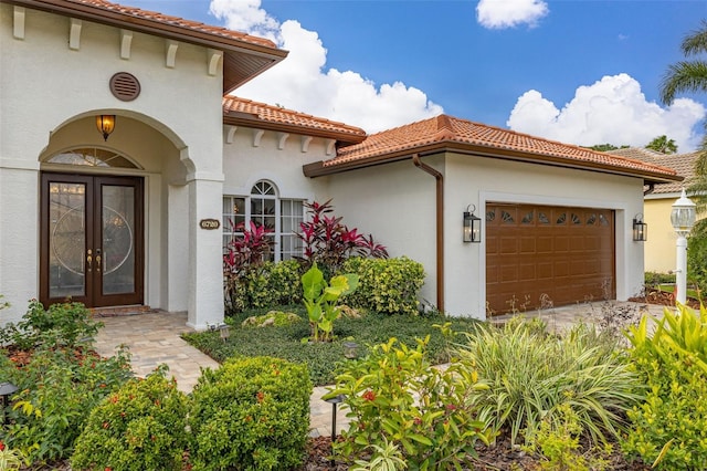 property entrance featuring a garage and french doors