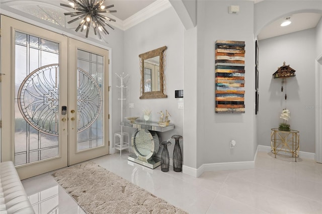 entrance foyer with french doors, crown molding, and a chandelier