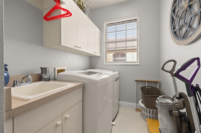 clothes washing area featuring cabinets, washing machine and dryer, and sink