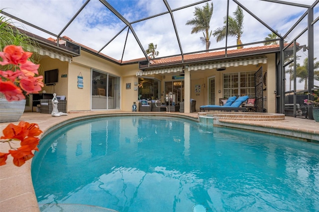 view of pool featuring ceiling fan, outdoor lounge area, a patio, and a lanai