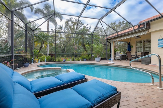 view of swimming pool with an in ground hot tub, ceiling fan, glass enclosure, and a patio area