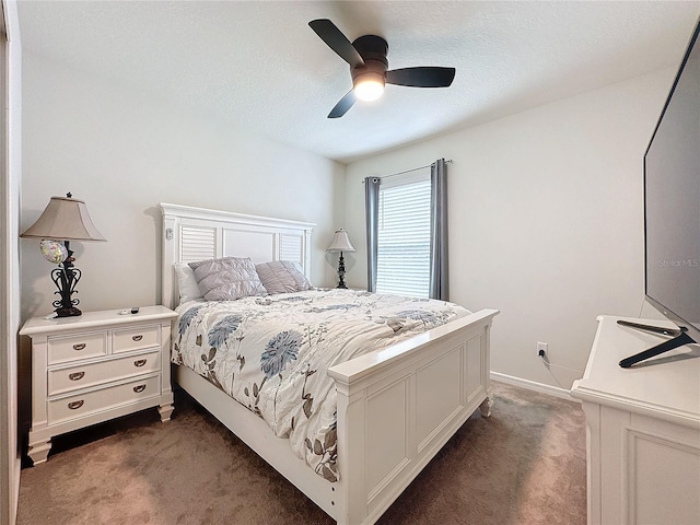 bedroom featuring dark carpet, a textured ceiling, and ceiling fan