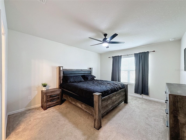 carpeted bedroom with ceiling fan and a textured ceiling