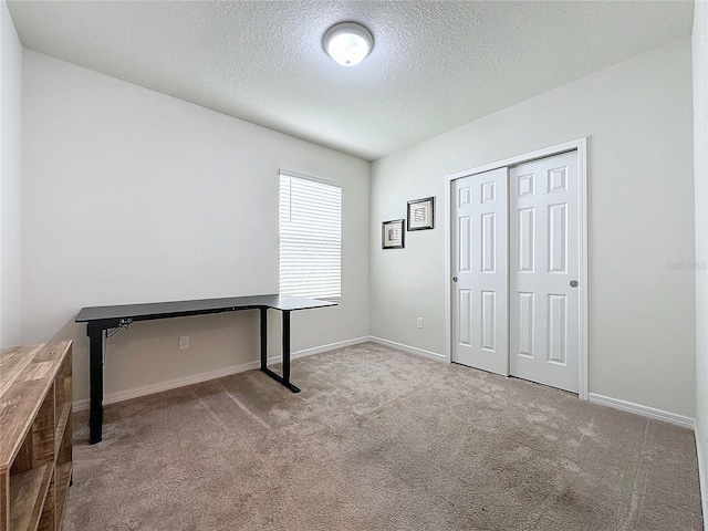 unfurnished office with light carpet and a textured ceiling