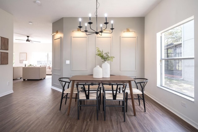 dining area with dark hardwood / wood-style flooring, ceiling fan with notable chandelier, and a wealth of natural light