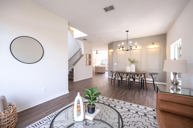 living room featuring an inviting chandelier and dark hardwood / wood-style floors