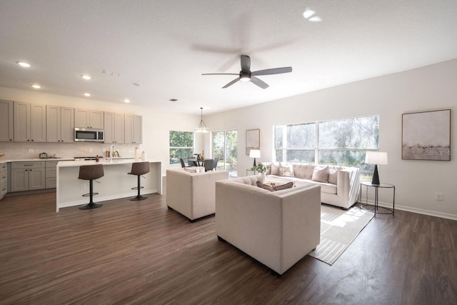 living room with dark wood-type flooring and ceiling fan