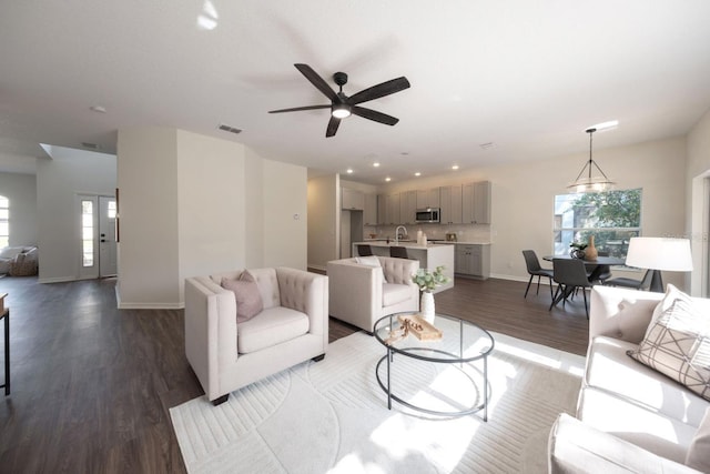 living room with ceiling fan, wood-type flooring, and sink