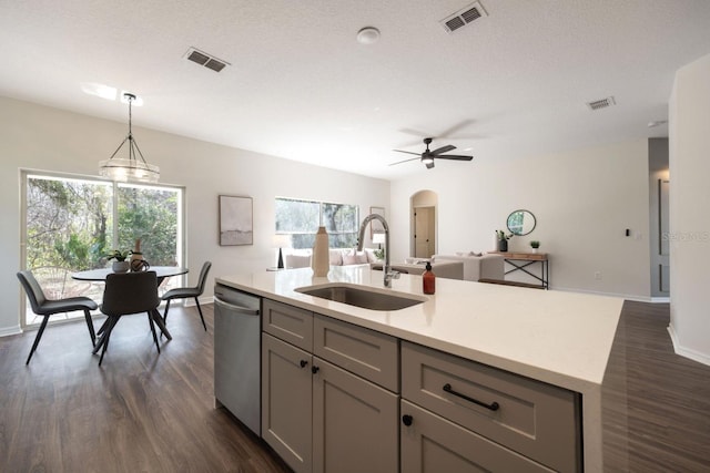 kitchen featuring sink, decorative light fixtures, gray cabinets, dishwasher, and a kitchen island with sink