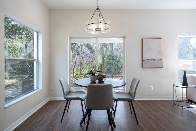 dining space featuring dark wood-type flooring and a chandelier