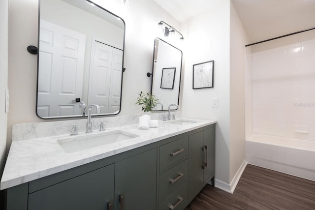 bathroom with wood-type flooring, shower / bathing tub combination, and vanity