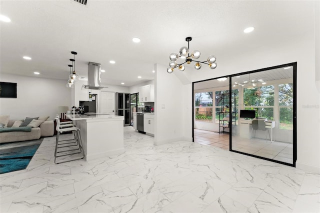 kitchen featuring island range hood, white cabinets, a textured ceiling, and decorative light fixtures