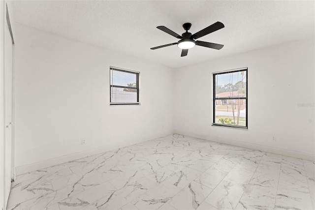 unfurnished room featuring ceiling fan and a textured ceiling