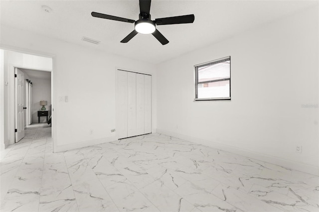 unfurnished bedroom with ceiling fan and a closet