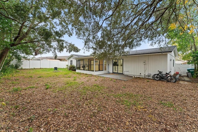 rear view of house featuring a patio area and a sunroom