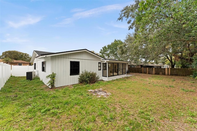 back of house with a yard, a sunroom, and central air condition unit