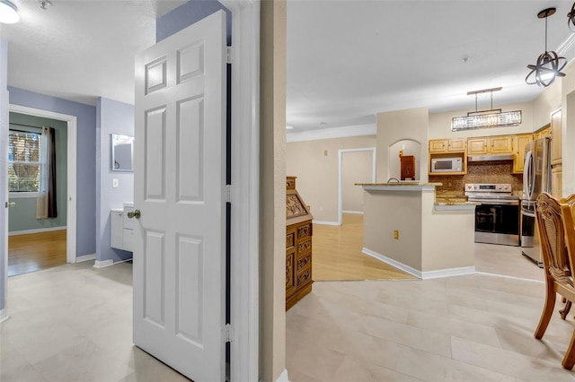 kitchen featuring tasteful backsplash, hanging light fixtures, stainless steel appliances, and a center island