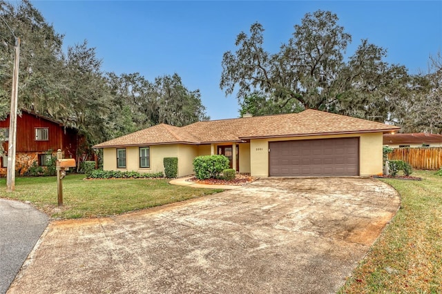 ranch-style house featuring a garage and a front lawn