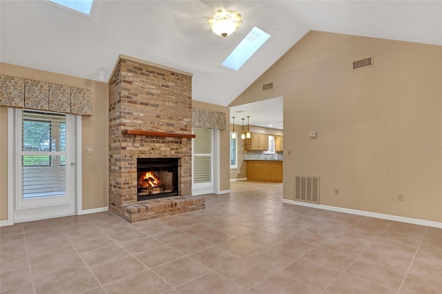 unfurnished living room featuring a fireplace, a skylight, high vaulted ceiling, and light tile patterned floors