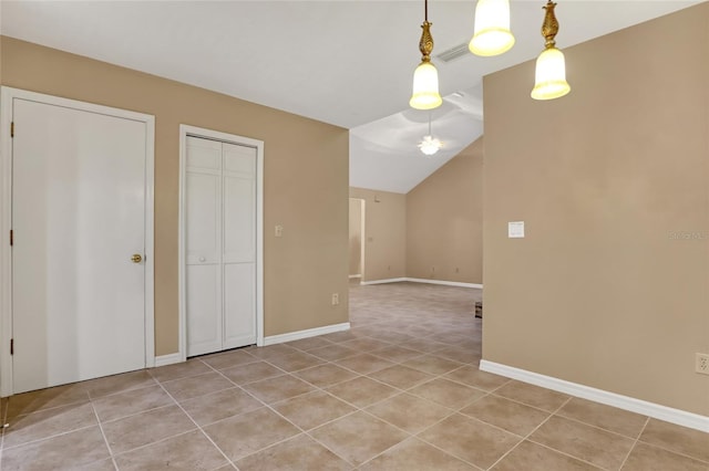 unfurnished dining area with vaulted ceiling and light tile patterned flooring