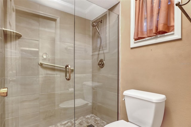 bathroom with an enclosed shower, ornamental molding, and toilet