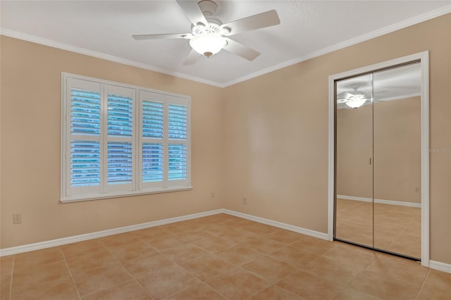 unfurnished bedroom featuring light tile patterned floors, crown molding, a closet, and ceiling fan