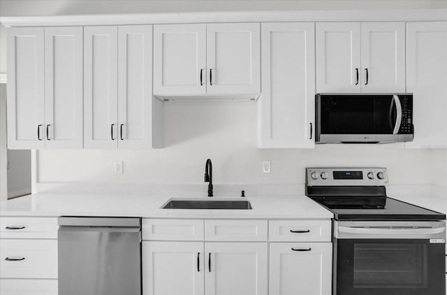 kitchen with stainless steel appliances, sink, and white cabinets