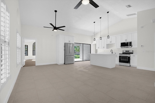 kitchen featuring appliances with stainless steel finishes, white cabinetry, hanging light fixtures, a center island, and ceiling fan