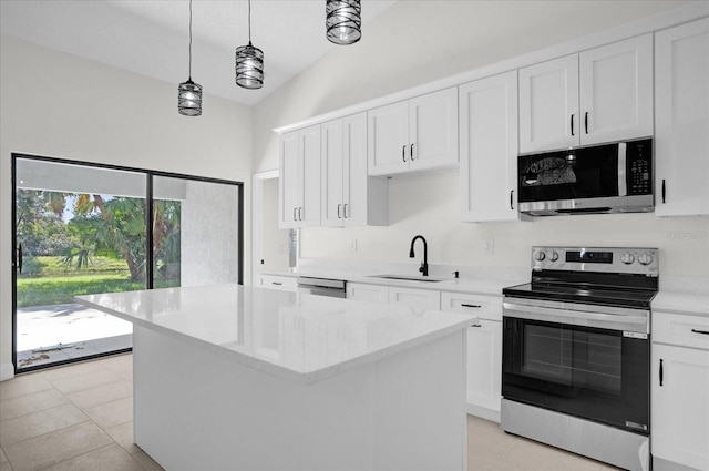 kitchen with stainless steel appliances, hanging light fixtures, white cabinetry, a sink, and a kitchen island