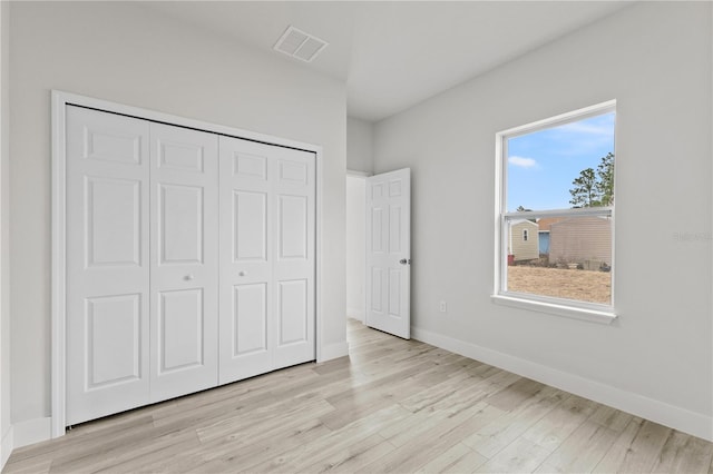 unfurnished bedroom with light hardwood / wood-style flooring and a closet