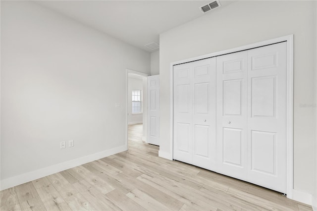 unfurnished bedroom featuring light wood-type flooring and a closet