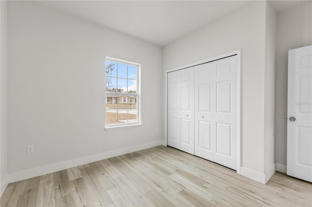 unfurnished bedroom featuring light hardwood / wood-style floors and a closet