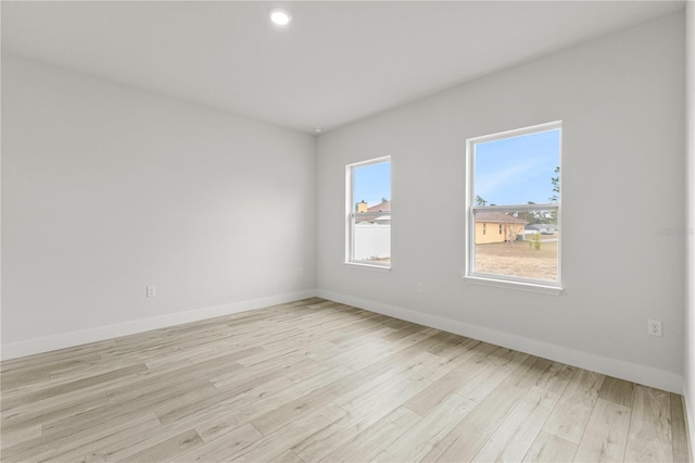 empty room with a healthy amount of sunlight and light hardwood / wood-style floors