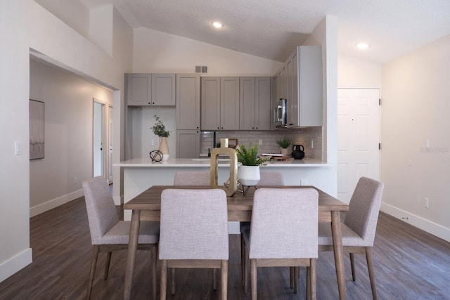 dining space featuring vaulted ceiling and dark hardwood / wood-style floors