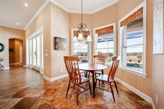 dining area featuring ornamental molding, a high ceiling, and a notable chandelier