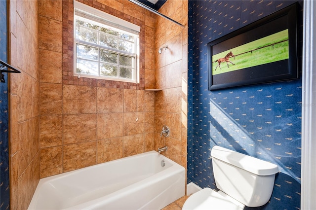 bathroom featuring toilet and tiled shower / bath combo