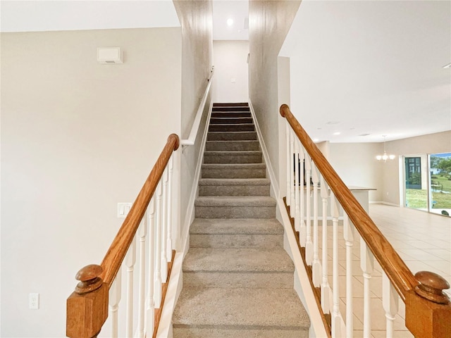 stairway with a notable chandelier