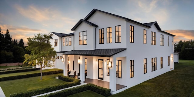 view of front of property with a patio and a lawn