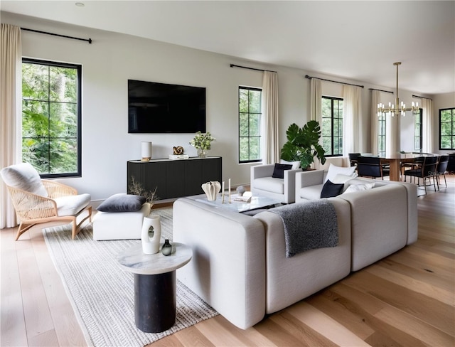 living room with an inviting chandelier and light hardwood / wood-style floors