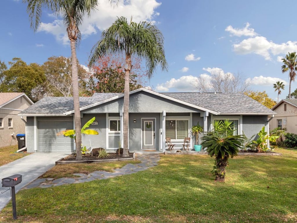 ranch-style house featuring a porch, a garage, and a front lawn