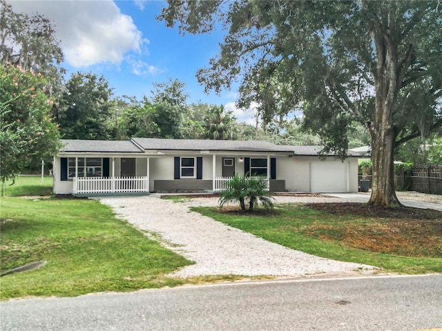 ranch-style house with a garage, covered porch, and a front lawn