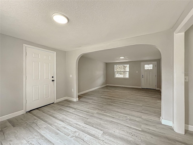 foyer entrance with a textured ceiling and light wood-type flooring