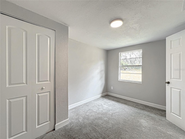 unfurnished bedroom with light colored carpet and a textured ceiling