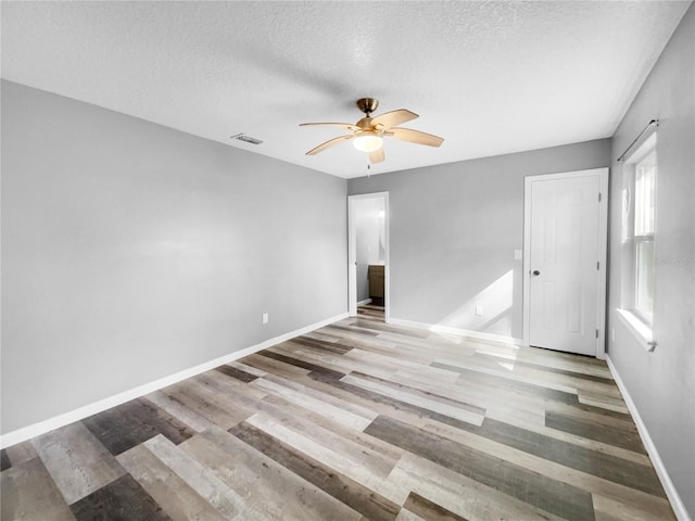 spare room featuring ceiling fan, a textured ceiling, and light hardwood / wood-style floors