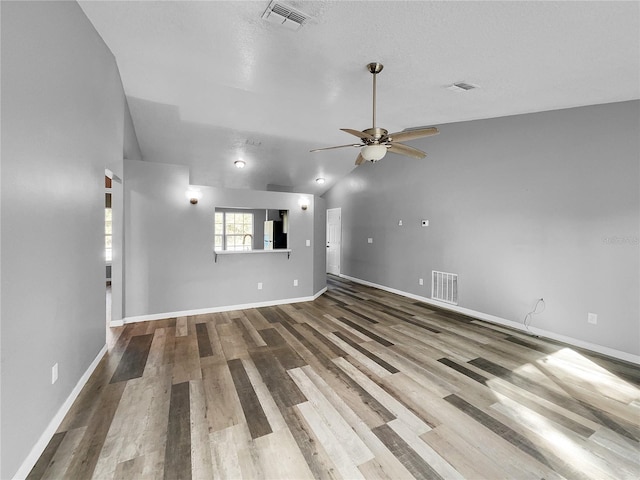 unfurnished living room featuring hardwood / wood-style flooring, ceiling fan, sink, and vaulted ceiling