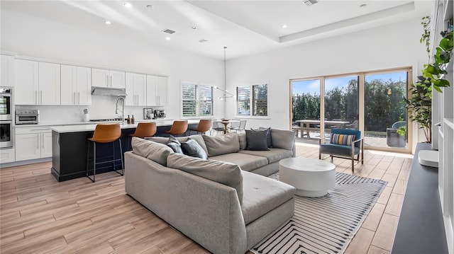 living room featuring a raised ceiling and a towering ceiling