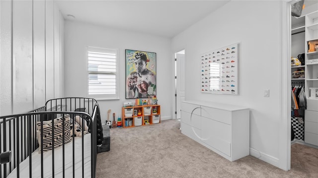 carpeted bedroom featuring a nursery area